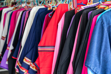 Colorful clothes of cotton fabric hanging on rail in store