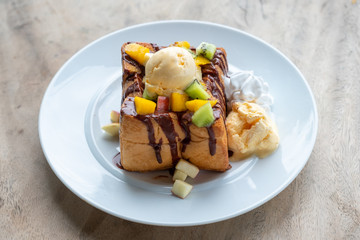 Honey toast ice cream vanilla with sliced fruits and chocolate sauce