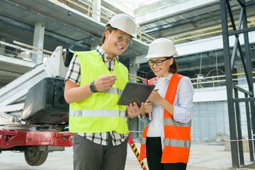 Woman architect and man builder at a construction site. Building, development, teamwork and people concept