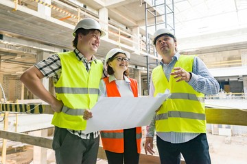 Group of engineers, builders, architects on the building site. Construction, development, teamwork and people concept