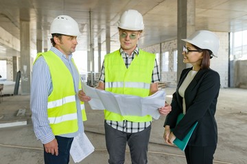 Group of engineers, builders, architects on the building site. Construction, development, teamwork and people concept