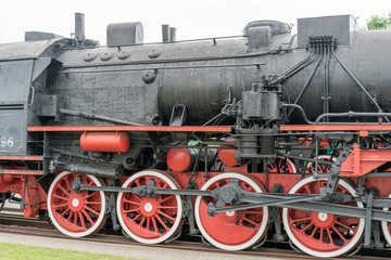 Fototapeta na wymiar Steam locomotive with red wheels. Retro locomotive on rails.