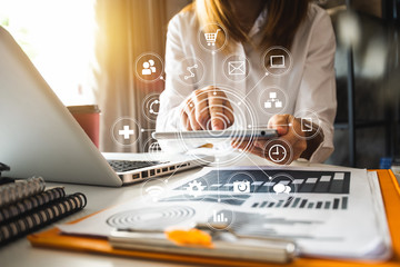 Digital marketing media in virtual screen.businesswoman hand working with mobile phone and modern compute with VR icon diagram at office in morning light