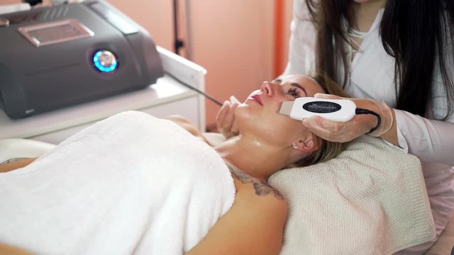 Ultrasonic face cleaning procedure. The work of beautician. Slowing down skin aging. Pore cleansing, black spots, oxygen saturation, dead skin cells.