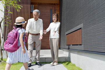 帰宅した孫娘を出迎えるシニア夫婦