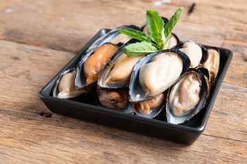 Raw mussels in black plate