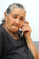 Old woman making a call with a smartphone