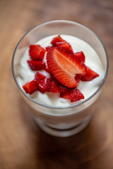 Sweet dessert in glass with berry fruit and whipped cream