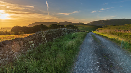 Sunset over a rural road in the Yorkshire Dales near Settle, North Yorkshire, England, UK