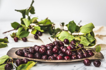 Fresh black cherries on a rustic metal plate