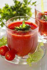 Fresh tomato juice with tomatoes and greens.