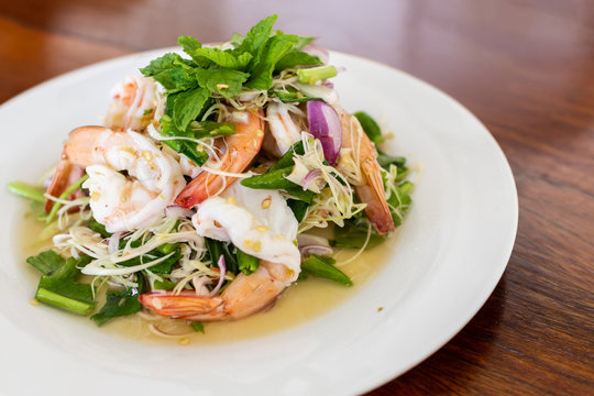 Close up image of  Shrimp salad with lemon grass and mint. Put on wooden table.
