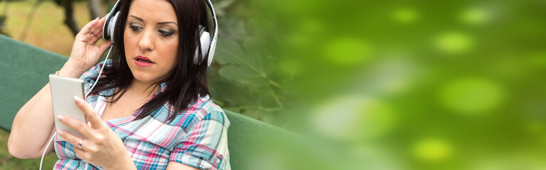 Pretty young woman listening to music with headphones