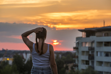 Fototapeta premium młoda dziewczyna obserwuje zachód słońca