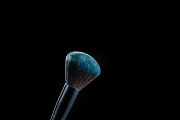 makeup brush with powder on black background