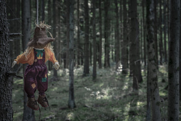 Fototapeta premium Scarecrow hanged with a rope in a dark forest