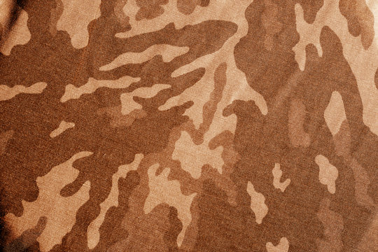 Old camouflage cloth with blur effect in orange tone.