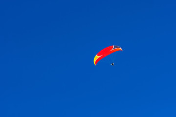 Flying paraglider in the blue sky