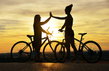 Two cyclist with bicycle in the sunset. Healthy lifestyle concept.