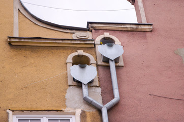 Decorated double drainpipe of two roofs on the wall of a building. Gdansk, Old City.