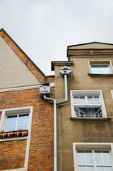 Decorated double metallic drainpipe of two houses on the wall of a building. Gdansk, Old City.