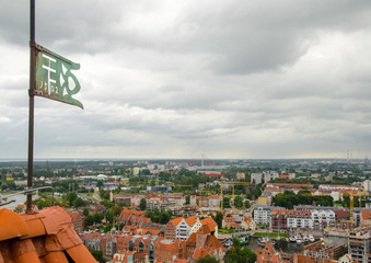 City of Gdansk in Poland, aerial view over the Old Town, view from Saint Mary's Church Tower. Cityscape of Gdansk at cloudy day with flag on the left side of the frame. Miniature effect.