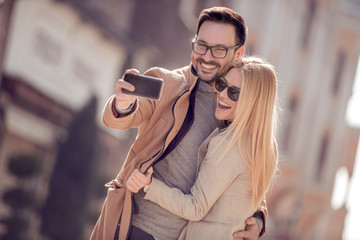 Loving couple taking selfie in the city