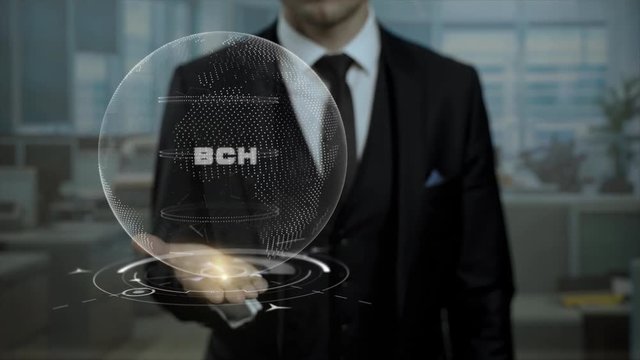 Male broker, head of crypto currency startup shows word BCH on his hand. Entrepreneur in suit holds cyber Earth hologram, presenting virtual technologies.