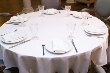 Enjoy a round dining table with white tablecloth in the restaurant