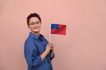 Samoa flag. Woman holding Samoa flag. Nice portrait of middle aged lady 40 50 years old with a...