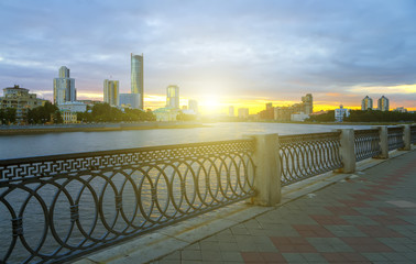 Obraz premium Yekaterinburg city center on sunset. City pond view, amazing clouds and sky. High buildings, skyscrapers on the embankment of the river Iset.