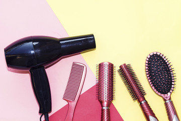 Professional hairdressing tools and black dryer isolated on colorful  background with copy space