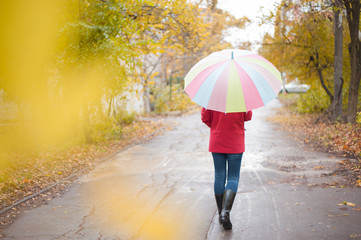 Woman walking with umbrella in a rainy autumn day
