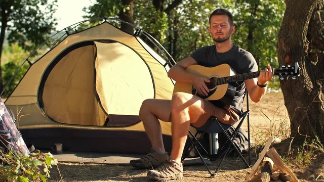 Backpacker with guitar at forest