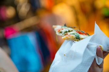 Woman eating Italian pizza to go.