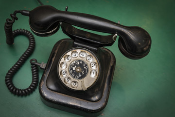 Vintage old telephone on green table background
