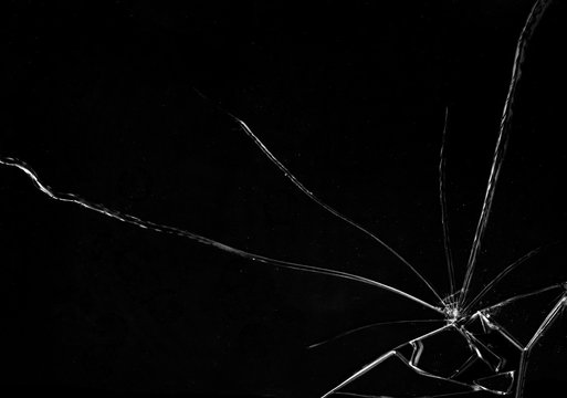 Shards of a broken glass on a black background, shattered pieces. Useful texture in overlay mode. Horizontal shot.
