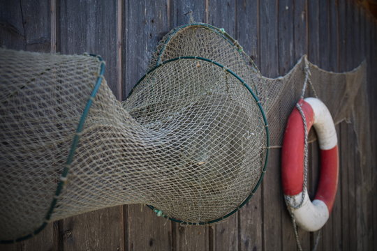 alte Fischreuse am Haus mit Rettungsring