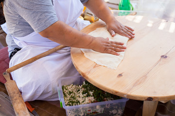 Pita bread with cottage cheese and greens. Preparing traditional bread on the street market.