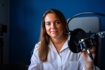mujer grabando un podcast en un estudio
