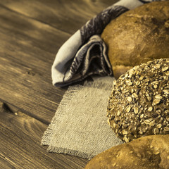 Rustic still life. Food. Assortment of fresh baked bread in the bakery on the background of a wooden table