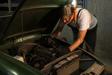 Male mechanic servicing a car