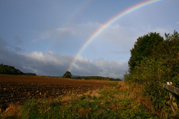 double rainbow over ploughed field