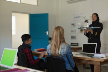 Female pilot teaching about model plane to kids