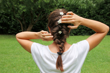 Naklejka premium Girl with hair braided and solanum jasmin fresh flowers in braid