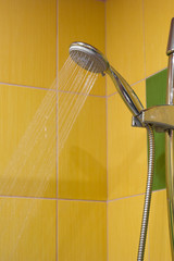 Naklejka na ściany i meble shower with water pressure, yellow tiles on the background