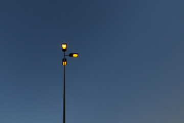 Street lamp with orange lights under blue sky
