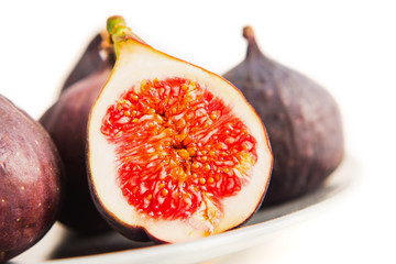 Fresh figs on grey plate. Fruit with half isolated on white.