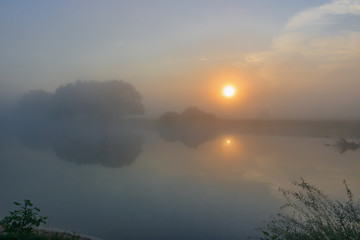 Fototapeta na wymiar Fog above the river surface. River landscape at sunrise in summer morning
