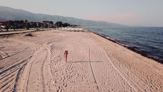 Girl walking alone at the beach in Greece